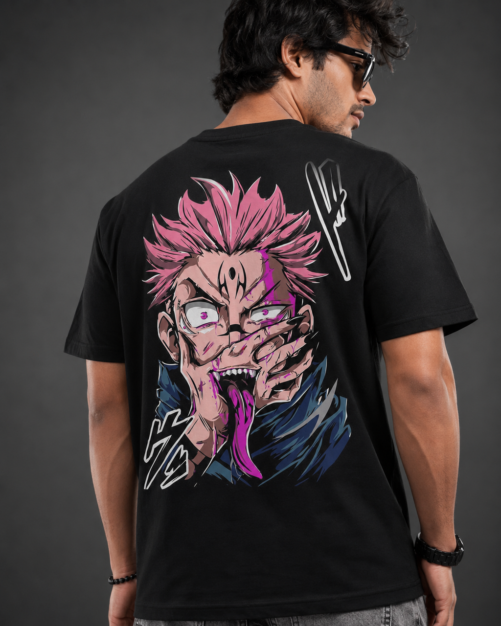 A man wearing a black t-shirt, viewed from the back, featuring a large graphic print of the anime character Tanjiro Kamado with pink hair and a purple tongue, on a dark gray background.